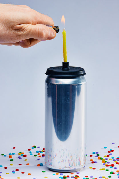 Lit Lids silicone candle holder on a beer can with lighter and hand